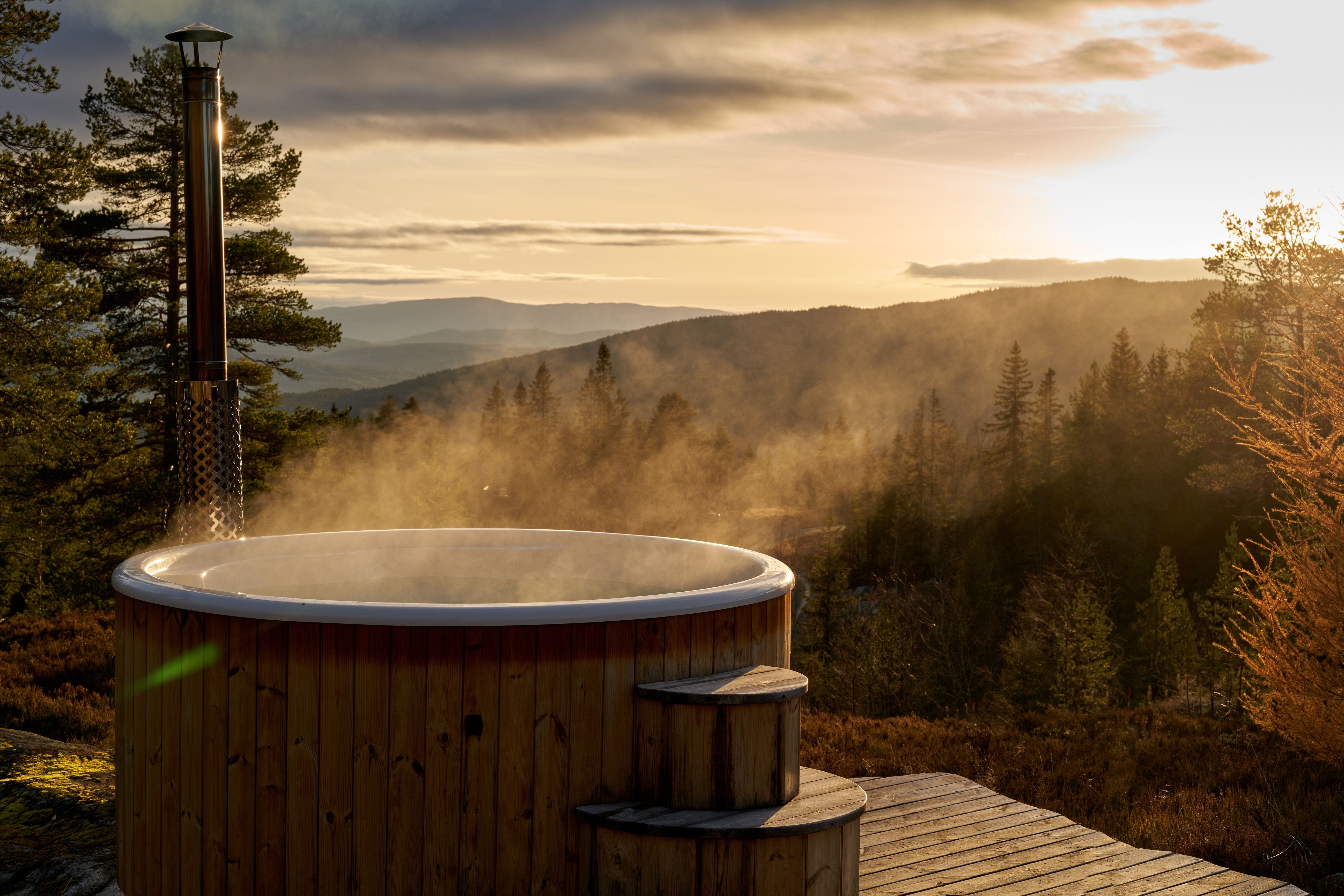 Bain nordique en bois chauffé au feu de bois face aux montagnes