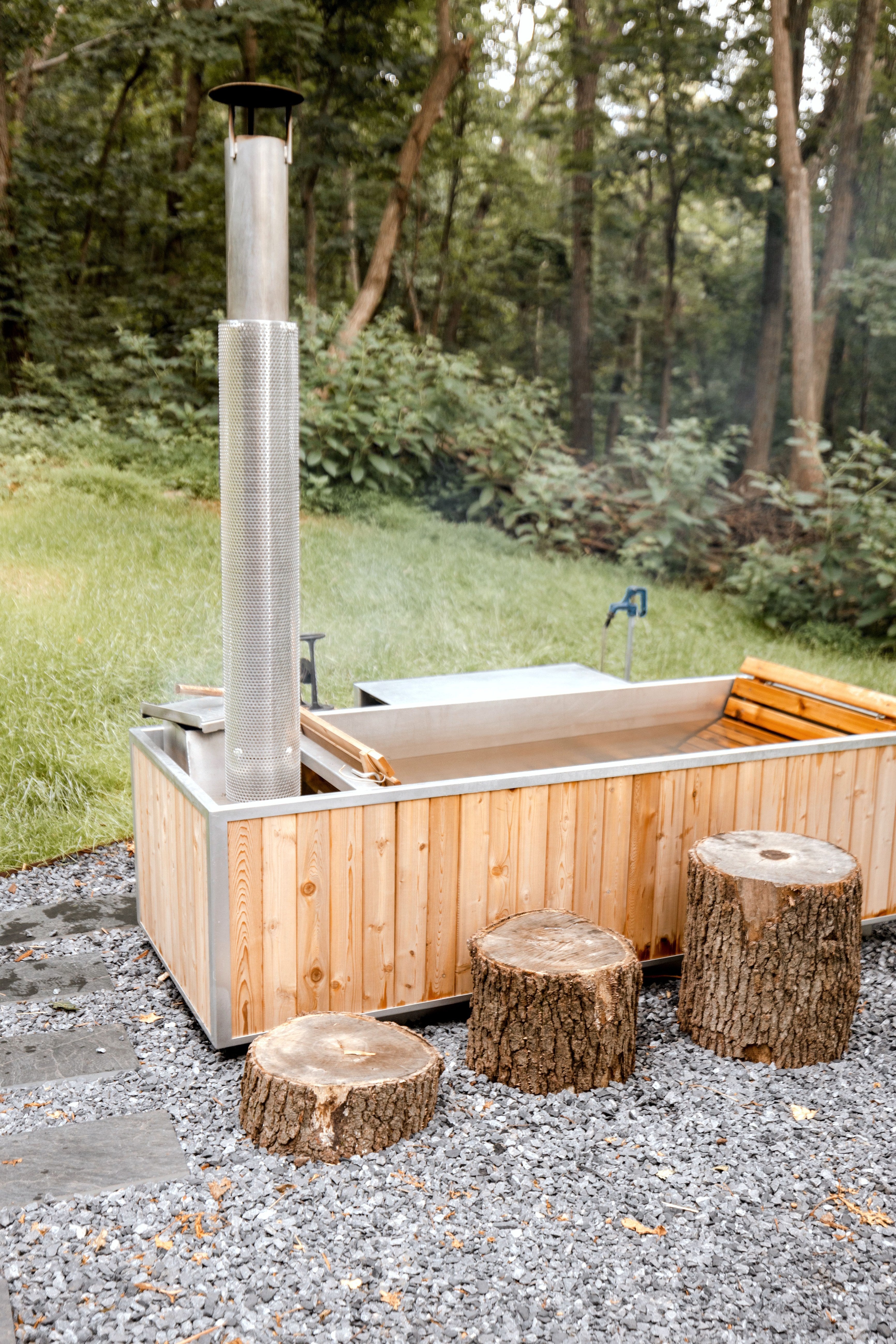 Bain nordique en bois installé sur une terrasse en forêt